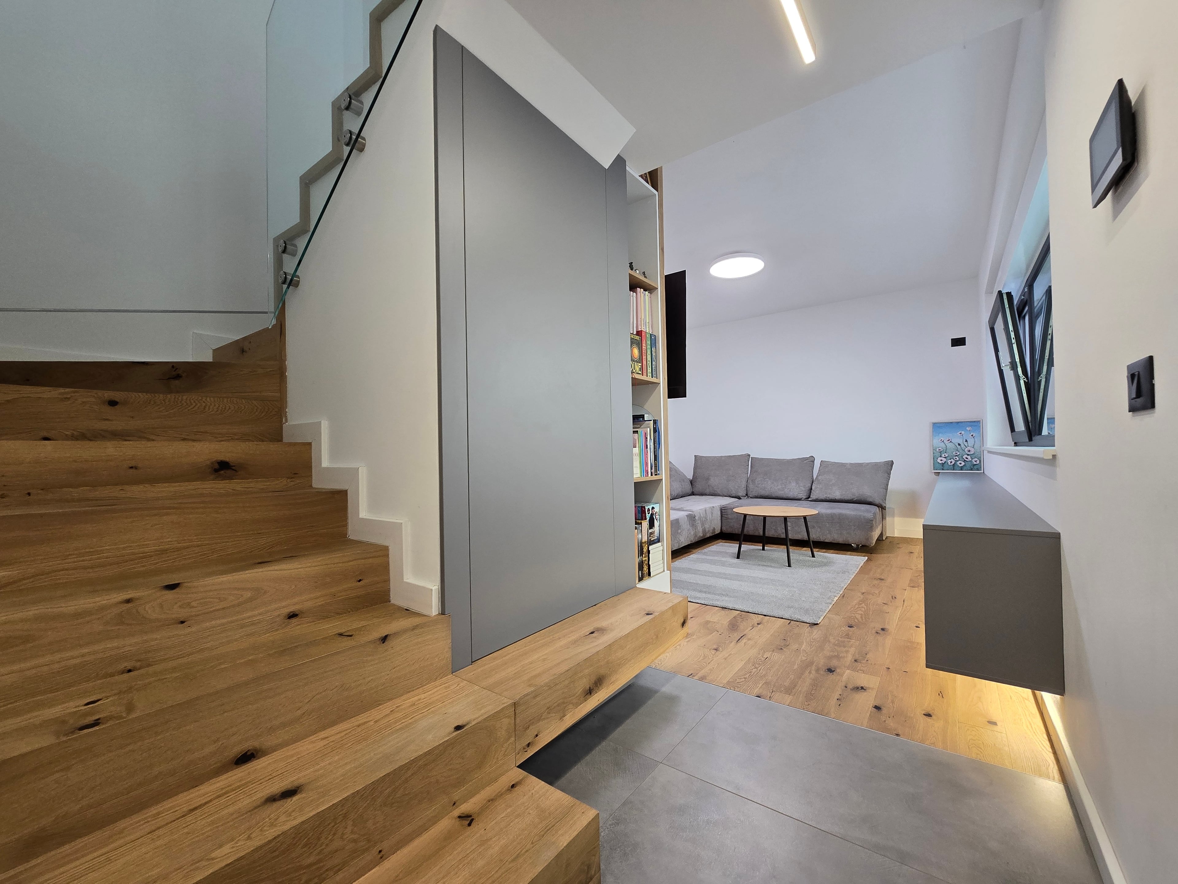 Detaliu de materiale: stejar masiv, gresie gri, balustradă din sticlă
